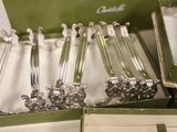 a lot of silver spoons in a green box