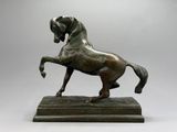 statue en bronze représentant un cheval dressé sur ses pattes arrière, posée sur un socle en marbre