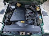 a green car with its hood open and the engine in the trunk