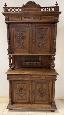 une vieille armoire en bois ornée de sculptures sur le dessus