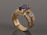 a close up of a gold ring with a tan sapphire and diamonds