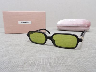 sunglasses are sitting on a table next to a pink box