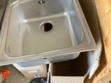 un évier dans un coin d'une pièce, entouré de cartons