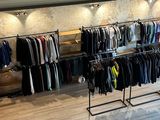 a lot of clothes hanging on a rack in a store