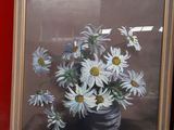 a picture of a vase with daisies in it next to a red wall