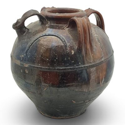 a large vase with a handle on it on a white surface