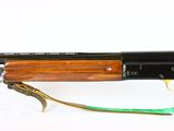 the rifle is sitting on a white surface with a green strap