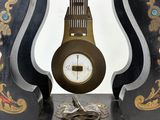 a black and gold clock on a stand with a white background