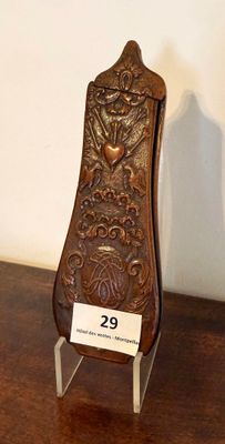 une petite horloge en bois posée sur un socle, sur une table