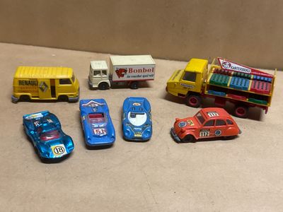 Plusieurs petites voitures et camions sont alignés sur une table