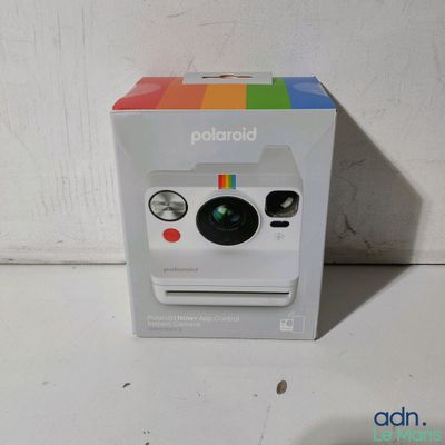 un appareil photo Polaroid dans la boîte posée sur la table