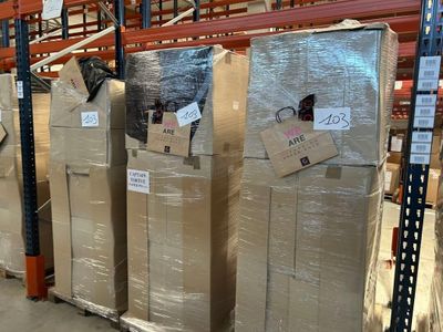 plusieurs réfrigérateurs empilés sur des palettes dans un entrepôt