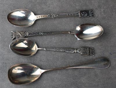trois cuillères en argent et deux cuillères en argent posées sur une table