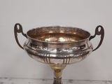 an antique silver plate with handles on a marble table