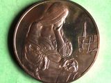 a close up of a coin on a green surface with a picture of a woman