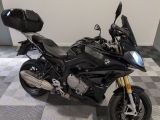 une moto noire garée dans une pièce au sol carrelé