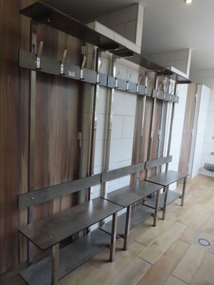 a long row of benches in a room with wooden walls