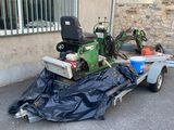 a trailer with a lawn mower attached to the back of it