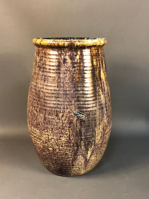 a brown vase sitting on a table with a gray background