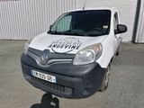 une camionnette blanche garée devant un immeuble sur lequel est accrochée une pancarte
