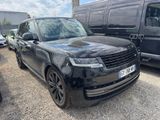 the black range rover is parked in a parking lot next to a van