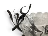 a glass bowl with a metal handle on a white surface