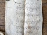 un vieux livre posé sur une table en bois, à côté d'une feuille de papier
