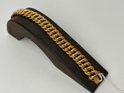 a close up of a gold chain on a black leather case