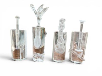 five glass vases with sand in them on a white surface