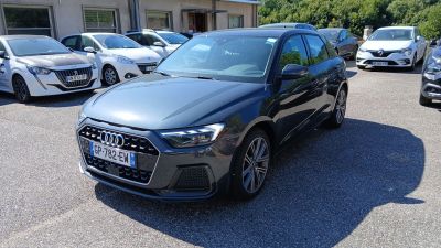 L'Audi est garée sur un parking, avec d'autres voitures en arrière-plan.