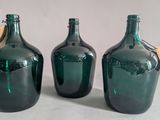 three green glass bottles with tags on them sitting next to each other
