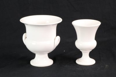 deux vases blancs posés l'un à côté de l'autre sur un fond noir