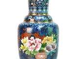 a blue vase with flowers on it sitting on a table