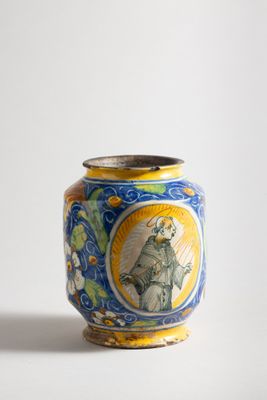 a blue and yellow vase with a picture of a man on it