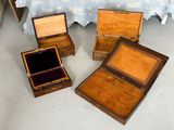 three small wooden boxes with velvet linings sit on the floor