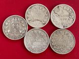 quatre pièces d'argent de tailles et de formes différentes sur un fond rouge