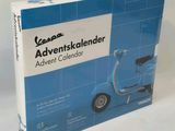 une image représentant un scooter bleu se trouve dans une boîte posée sur une surface blanche