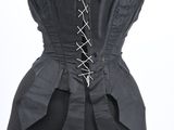 the back of a black corset with a bow tie on a mannequin mannequin