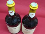 two bottles of wine sitting next to each other on a red cloth