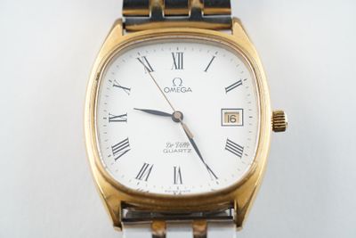une montre en or et blanc avec des chiffres romains