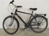 un vélo noir appuyé contre un mur
