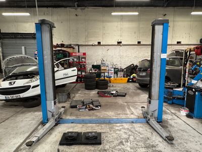 une voiture posée sur un pont élévateur dans un garage