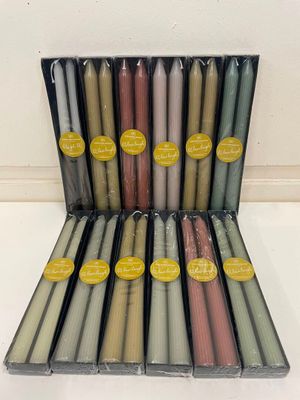 une boîte contenant 12 bougies de couleurs différentes empilées les unes sur les autres
