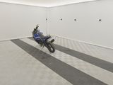 une moto qui est garée dans une pièce dont le sol est en damier