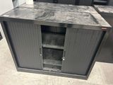 une armoire métallique dont la porte est ouverte et repose sur le sol