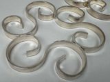 several pieces of metal are arranged in a circle on a white surface