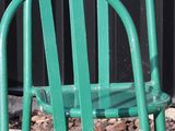 a green chair sitting in front of a black wall