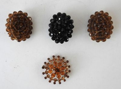 three small beaded flower brooches are shown on a white surface