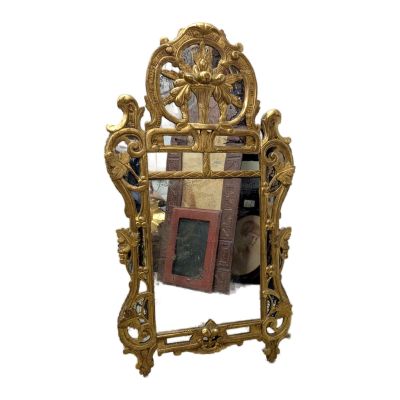 un miroir avec un cadre doré et une image dessus