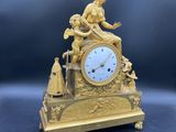 une horloge en or avec une femme assise dessus